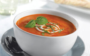 Tomato bisque in a white bowl.