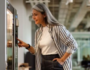 Woman looking into a vending machine for a snack to purchase