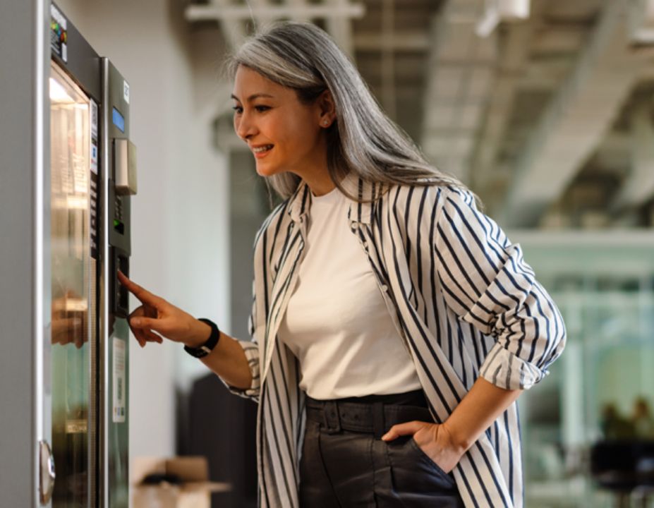 Woman looking into a vending machine for a snack to purchase