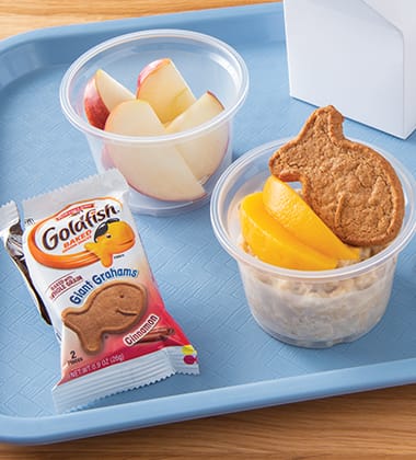 OATMEAL TOPPED WITH PEACHES AND GIANT GOLDFISH® MADE WITH WHOLE GRAIN GRAHAMS